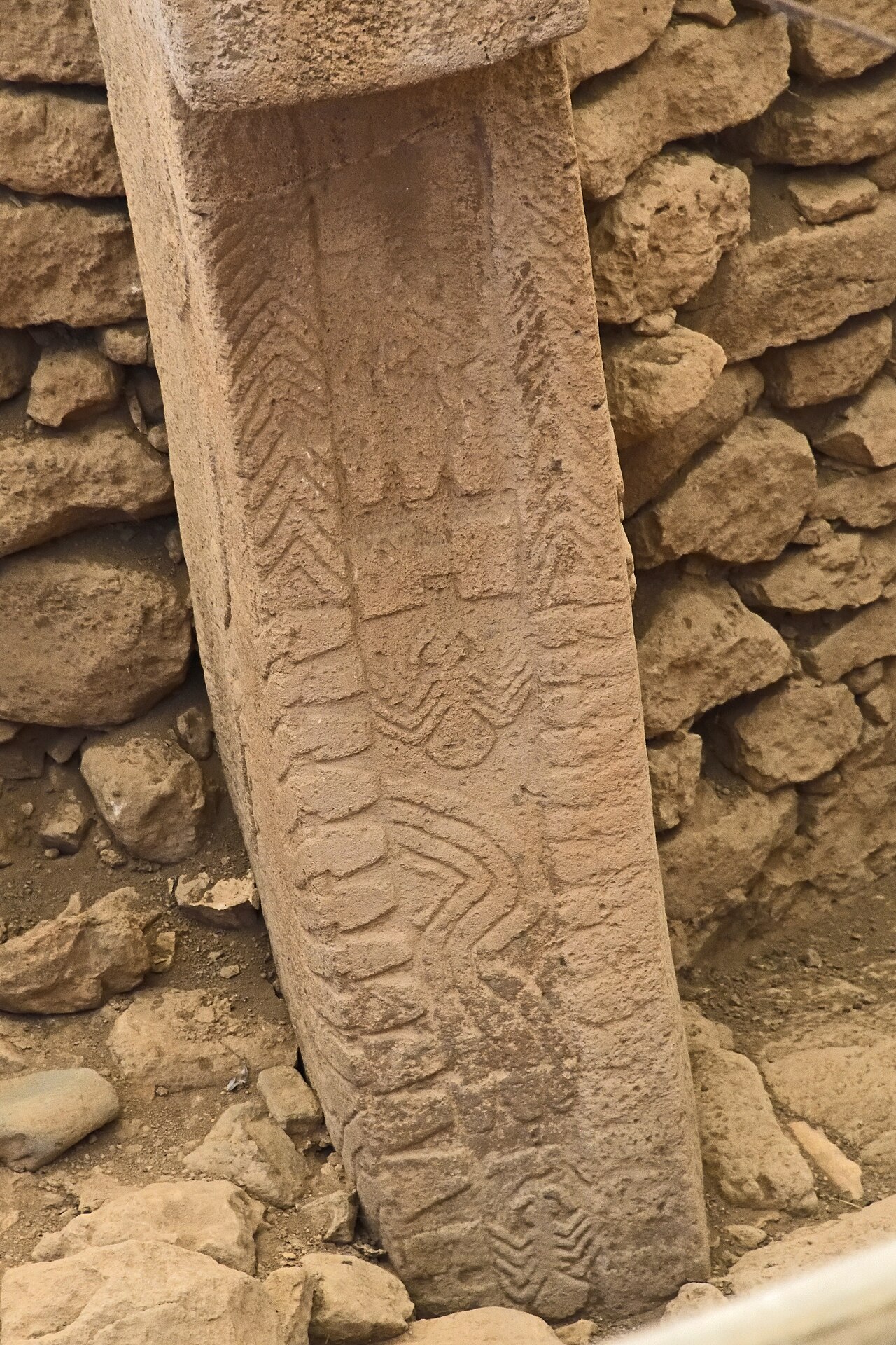 Bundles of carved snakes descending a T-shaped pillar in Enclosure D at Göbekli Tepe, with a spider carved below